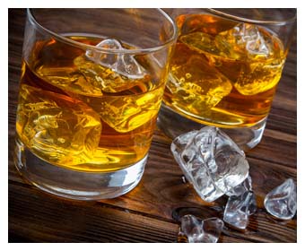 dos vasos de whisky con hielo